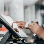 用紙を見ながら端末を操作する人のイメージ
